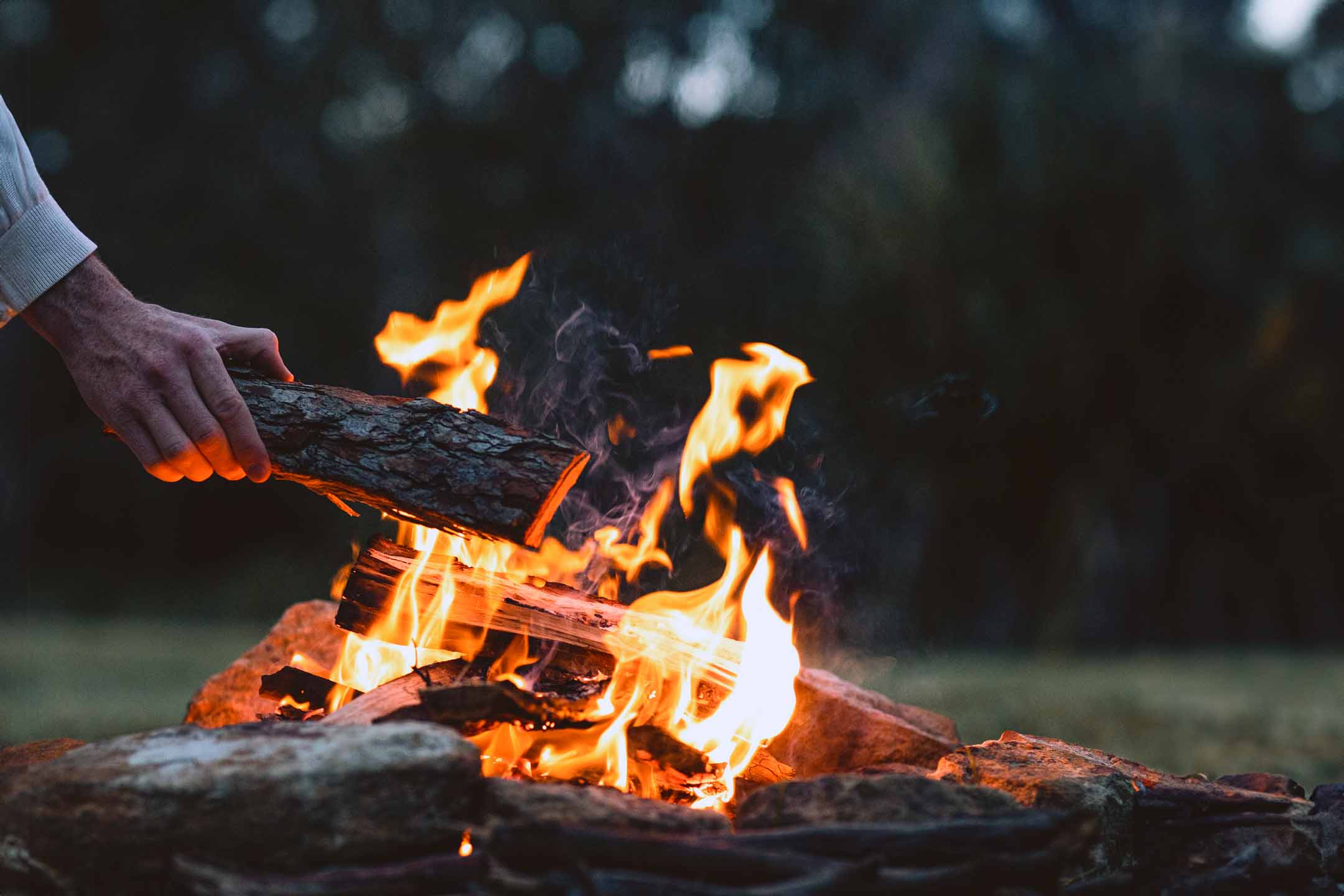 Brennholz wird in Feuer gelegt